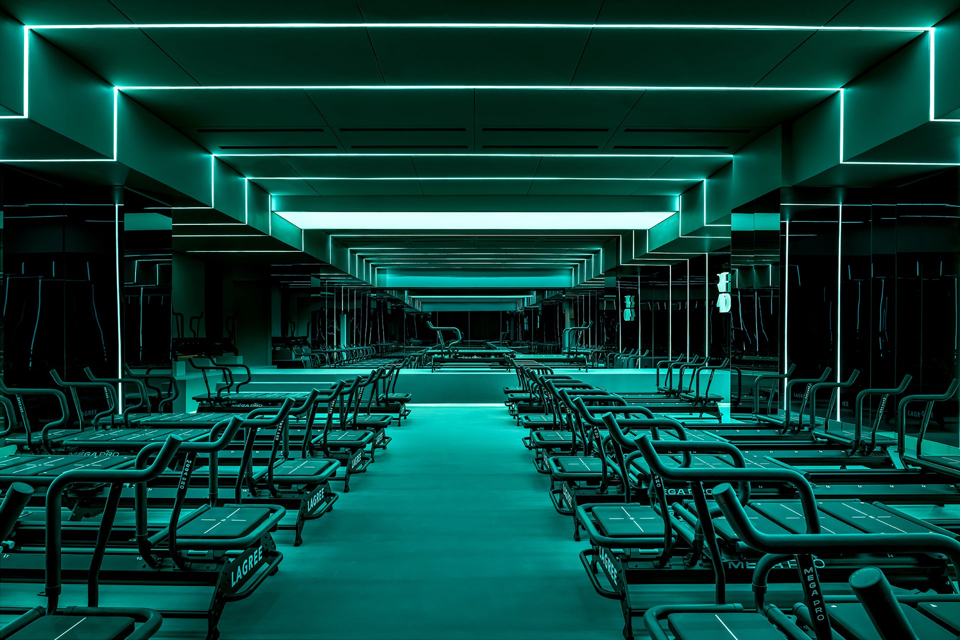 Modern neon lit gym and Lagree megaformer exercise machines